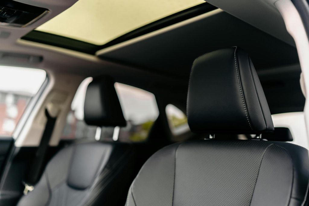 Explore the modern luxury of a car interior featuring leather seats and a sunroof.